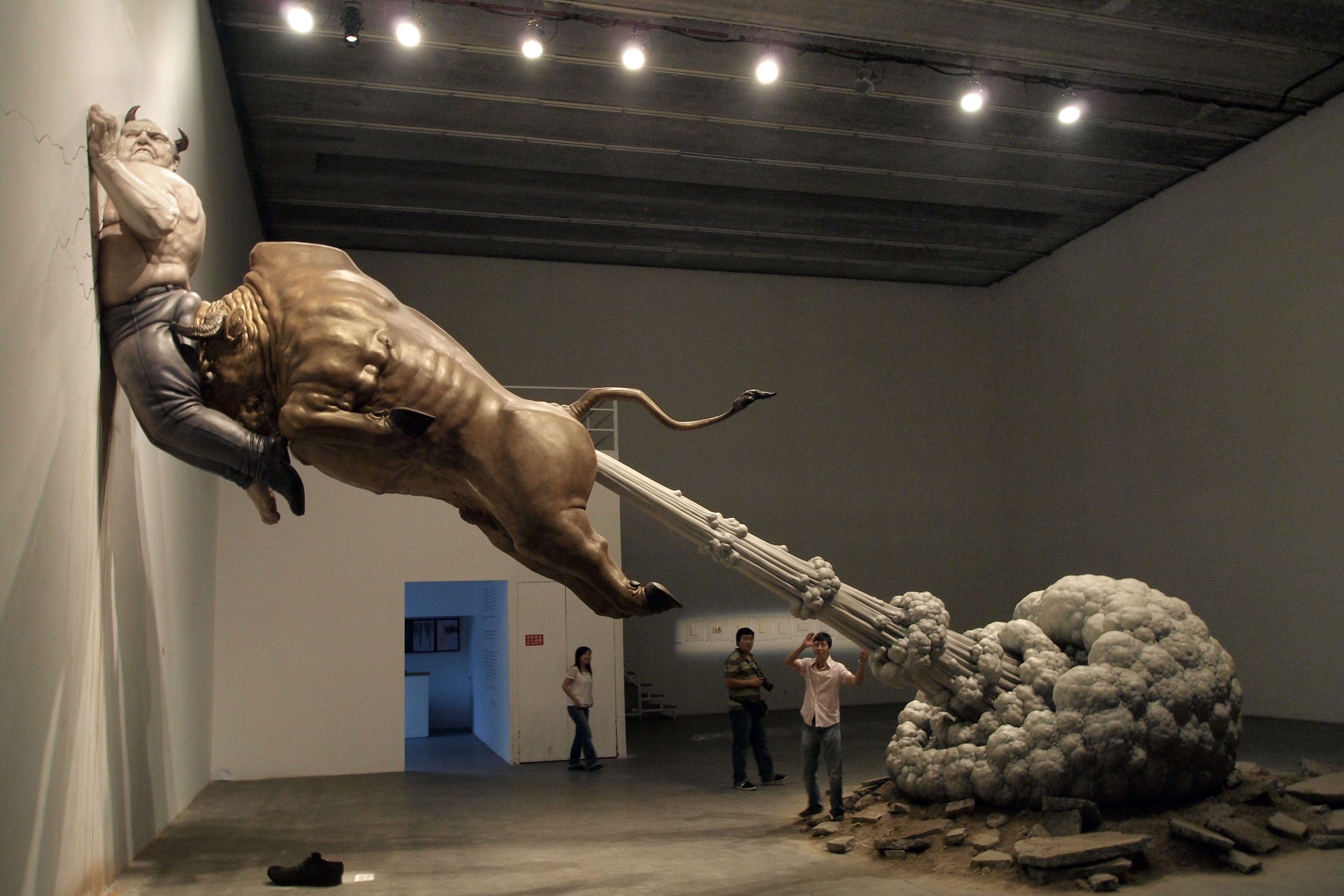 In this photo taken Sunday, Sept. 27, 2009, a sculpture by Chinese artist Chen Wenling entitled "What You See Might Not Be Real" is on display at a gallery in Beijing, China. The artwork is a critique of the global financial crisis with the bull representing the golden bull of wall street and the man pinned to the wall representing the jailed financier Bernard Madoff. (AP Photo/Ng Han Guan)